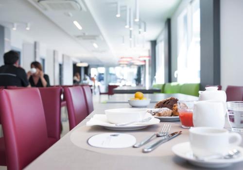 een tafel met borden en keukengerei en eten erop bij Milano Resort in Bellaria-Igea Marina