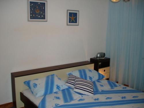 a bed with blue sheets and pillows in a bedroom at Holiday home Boris - close to sea in Slatine