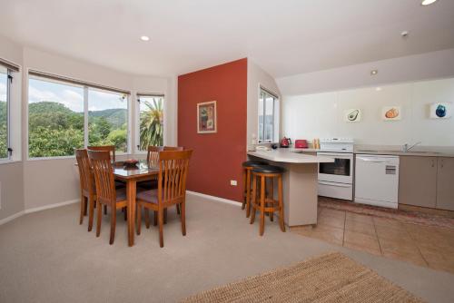 a kitchen with a table and chairs in a room at Waimarie on Riverside Motel & Apartments in Nelson