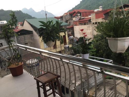 a balcony with a chair and some plants and buildings at Ruby Hostel in Ha Giang