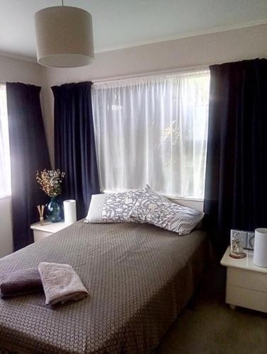 a bedroom with a bed in front of a window at rooms with a view in Haywards