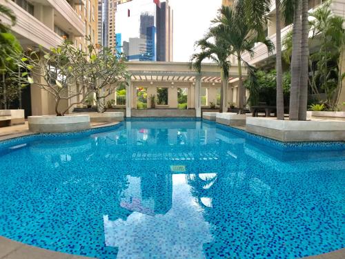 a large blue swimming pool in a building at Twin Peaks Sukhumvit Suites in Bangkok