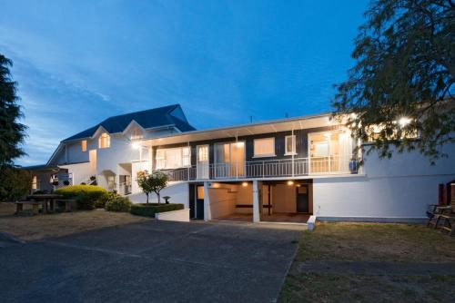 a large white house with a driveway at Waimarie on Riverside Motel & Apartments in Nelson