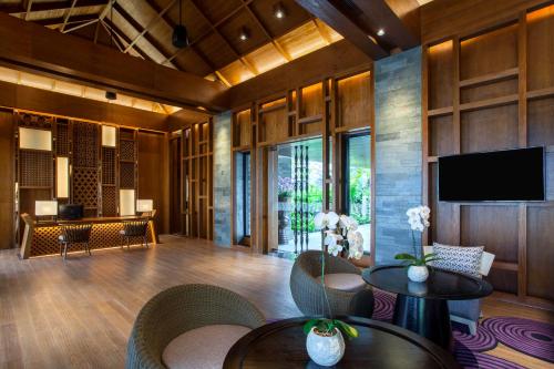a lobby with a television and chairs and a table at Pullman Ciawi Vimala Hills Resort in Bogor