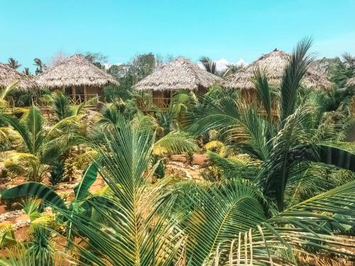 a village with thatched huts and palm trees at Mandala Tribe Treehouses in Siquijor