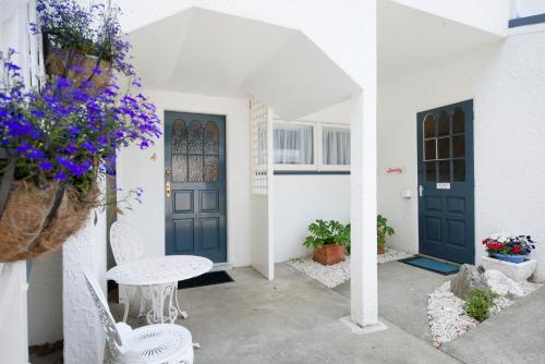 a courtyard with a blue door and a table and chairs at Waimarie on Riverside Motel & Apartments in Nelson