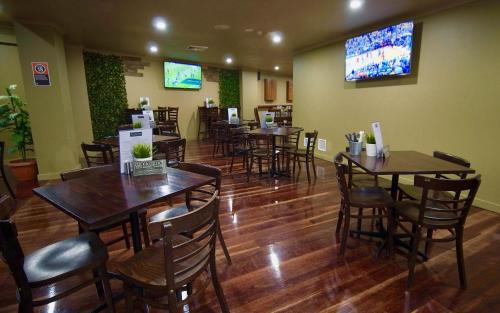 a restaurant with tables and chairs in a room at Argyle Hotel Southern Highlands in Moss Vale