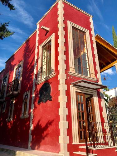 a red building with a black face painted on it at Hotel San Miguel in Contepec