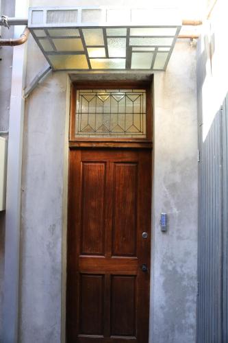 - une porte en bois dans un bâtiment avec une fenêtre dans l'établissement Studio 7 - Saint George Accommodation, à Melbourne