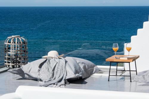 a table with a blanket and two glasses of wine at Merchia Bay Villas Mykonos in Merchia Beach
