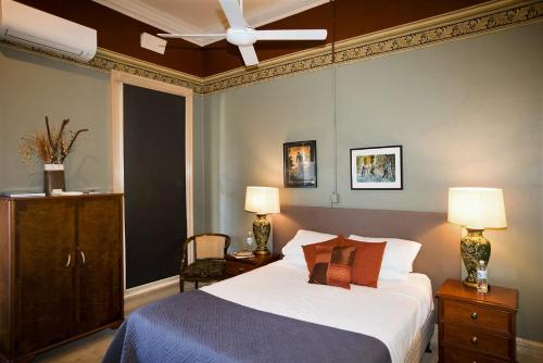 a bedroom with a bed and a ceiling fan at Delatite Hotel in Mansfield