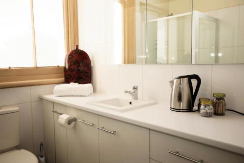 a kitchen counter with a sink and a mirror at Delatite Hotel in Mansfield