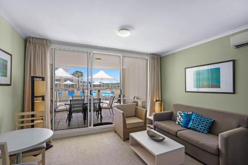 a living room with a couch and a table at Ettalong Beach Luxury Apartments in Ettalong Beach