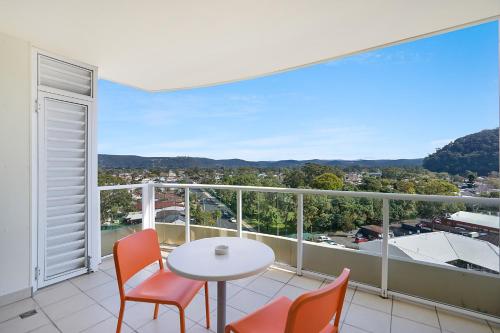 a balcony with a table and chairs and a view at Ettalong Beach Luxury Apartments in Ettalong Beach