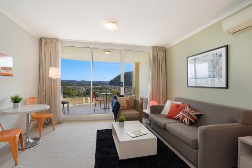 a living room with a couch and a table at Ettalong Beach Luxury Apartments in Ettalong Beach