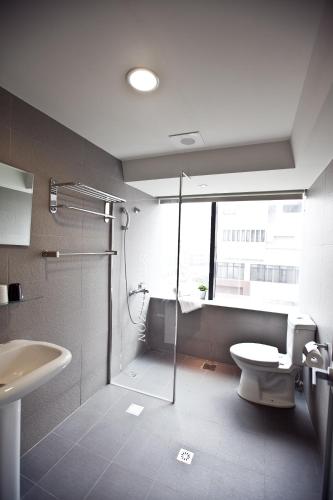 a bathroom with a shower and a toilet and a sink at Sodamazon Business Hotel in Zhongli