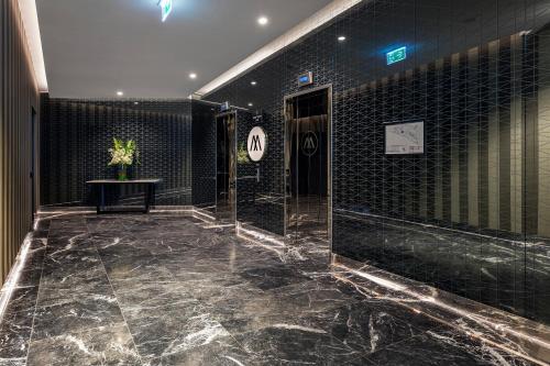 a bathroom with black tile walls and a marble floor at Imagine Marco in Melbourne