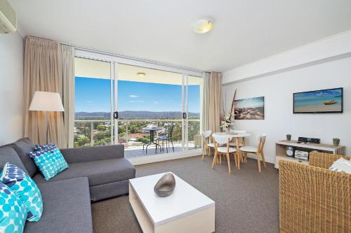 a living room with a couch and a table at Ettalong Beach Luxury Apartments in Ettalong Beach