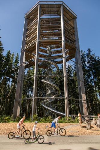 three people riding bikes in front of a clock tower at Apartmán Riviéra Lipno 510/21 in Lipno nad Vltavou
