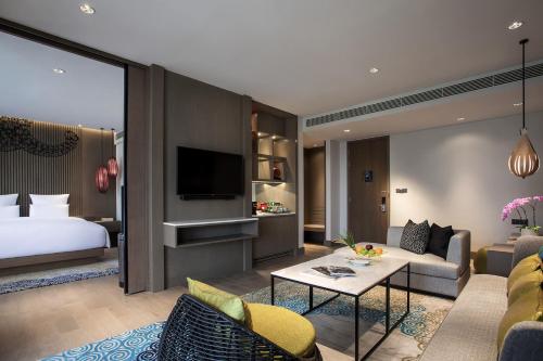 a hotel room with a bed and a living room at Pullman Ciawi Vimala Hills Resort in Bogor