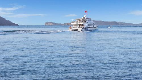 a white boat in the water on a lake at Ettalong Beach Luxury Apartments in Ettalong Beach
