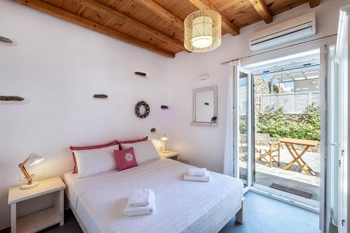 a bedroom with a bed and a balcony at Exochi Traditional Houses in Krotiri