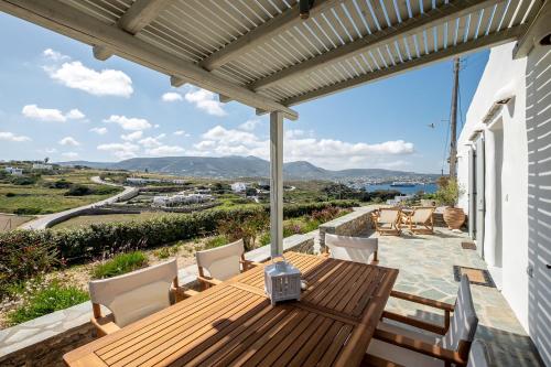 a deck with a wooden table and chairs on a house at Exochi Traditional Houses in Krotiri
