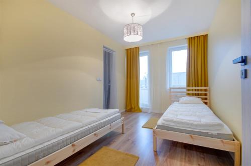Habitación con 2 camas y ventana grande. en Apartment Kordiana, en Cracovia