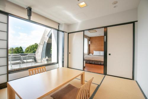 a dining room with a table and a large window at Rembrandt Premium Fuji Gotenba in Gotemba