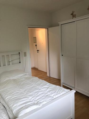 ブラウンラーゲにあるFerienwohnung Wandervogelのクローゼット付きの客室の白いベッド1台
