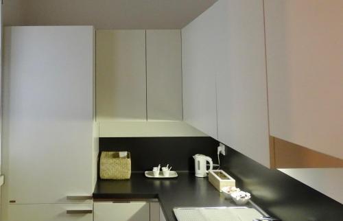 a kitchen with white cabinets and a black counter top at Accademia 35 in Mantova