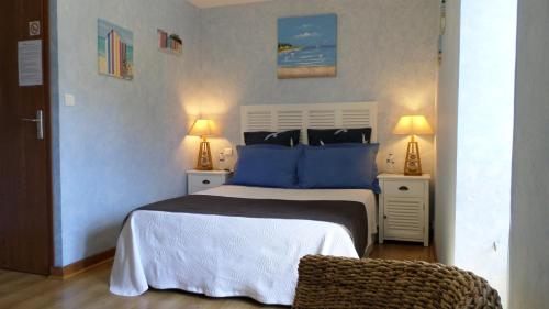 a bedroom with a large bed with blue pillows at Chambres d'Hôtes La Rompardais in Pléven