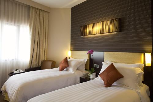 a hotel room with two beds and a window at Hotel Royal Queens in Singapore