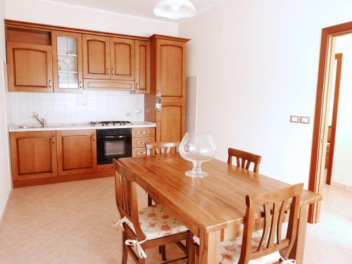 a kitchen with a wooden table and wooden cabinets at B&B da Eli in San Pietro