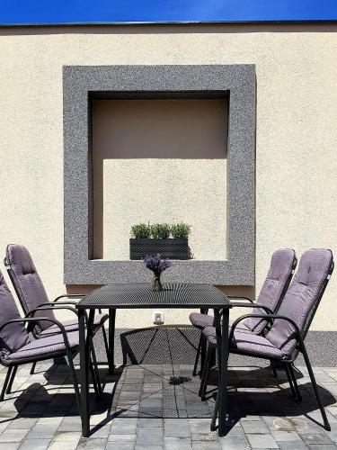 a black table with purple chairs in front of a mirror at Penzion U Křížku in Kobylí