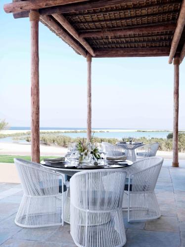 a white table with white chairs and a table and chairsktop at Anantara Sir Bani Yas Island Al Yamm Villa Resort in Da‘sah