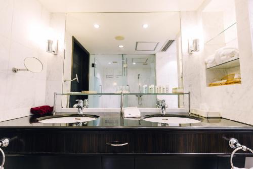 a bathroom with two sinks and a large mirror at Okura Garden Hotel Shanghai in Shanghai