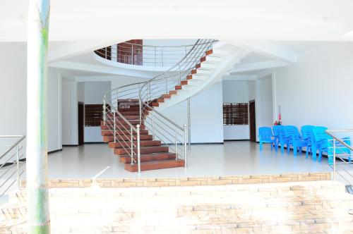 a staircase in a building with blue chairs at Sunstar Nilaveli in Trincomalee