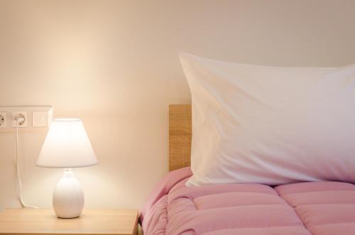 a bedroom with a bed with a white pillow and a lamp at Chrisella Villa in Skala Rachoniou