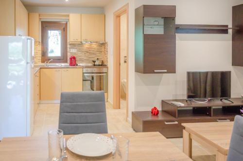a kitchen and living room with a table and a refrigerator at Chrisella Villa in Skala Rachoniou