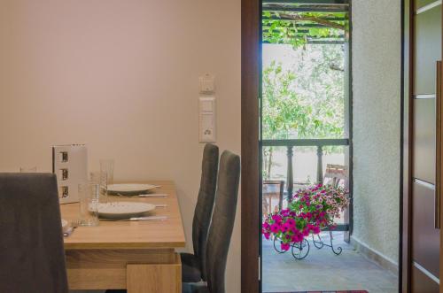 a dining room with a table with chairs and a window at Chrisella Villa in Skala Rachoniou