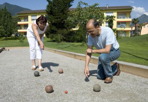 a man and a woman playing with balls on a road at Parkhotel Emmaus - Casa Rustico in Ascona