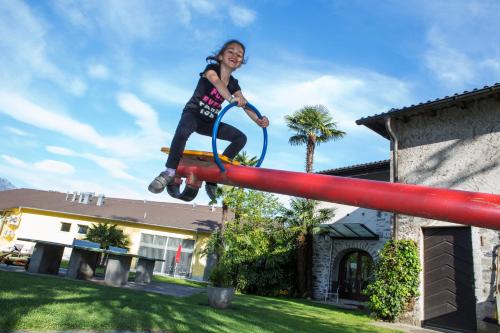 a young girl is jumping on a pole at Parkhotel Emmaus - Casa Rustico in Ascona