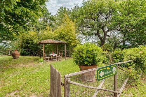 a sign in a garden with a gazebo at Podere Casanova in Montespertoli