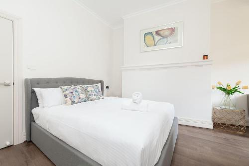 1 dormitorio blanco con 1 cama grande con sábanas blancas en STUNNING SYDNEY HOME 9, en Sídney