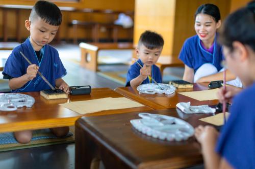 a group of children sitting at a table eating food at Narada Resort & Spa Perfume Bay Sanya - All Villas in Lingshui