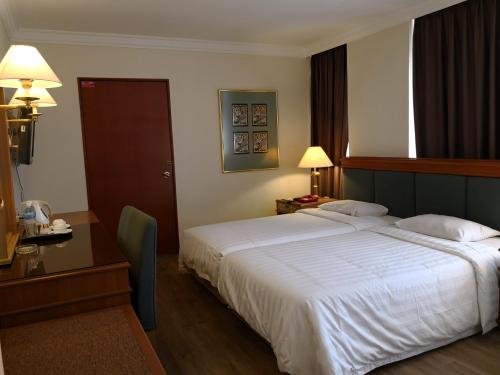 เตียงในห้องที่ The Executive Hotel Lahad Datu