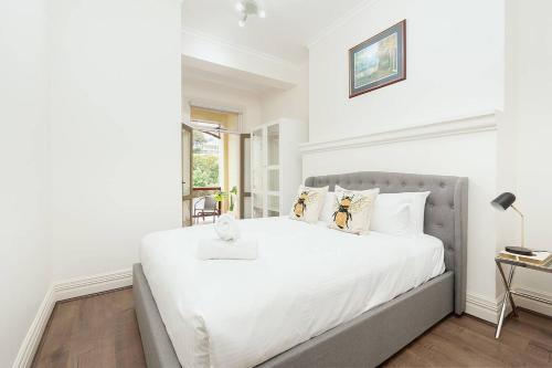 a white bedroom with a large bed and a window at STUNNING SYDNEY HOME 3 in Sydney