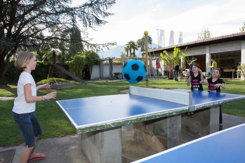 a group of children playing a game of ping pong at Parkhotel Emmaus - Casa Rustico in Ascona