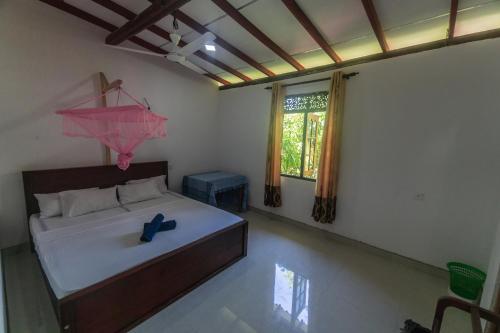 um quarto com uma cama com um guarda-chuva cor-de-rosa em Mango Shade Weligama em Weligama